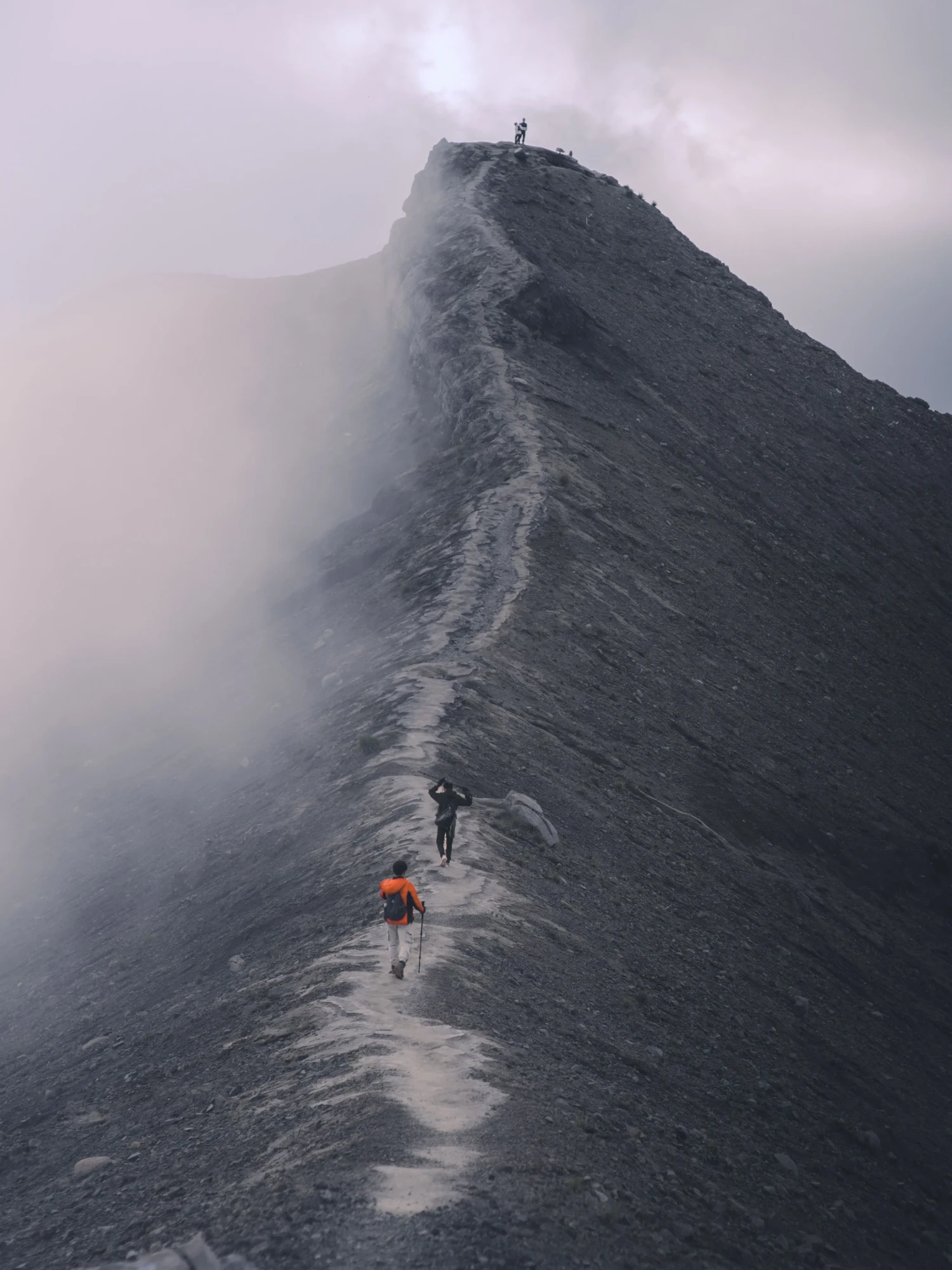霧に包まれた稜線を歩く登山者たち